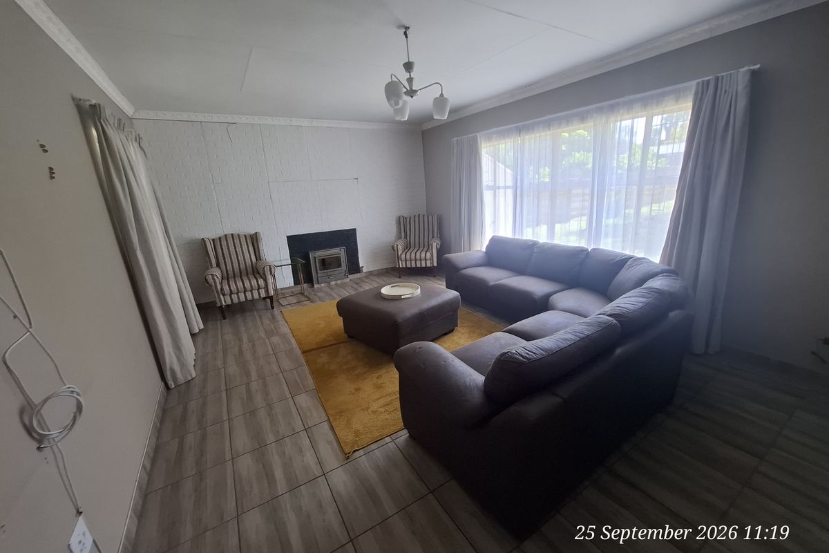 Spacious living room featuring tiled flooring, a built-in fireplace, and large windows allowing for natural light.