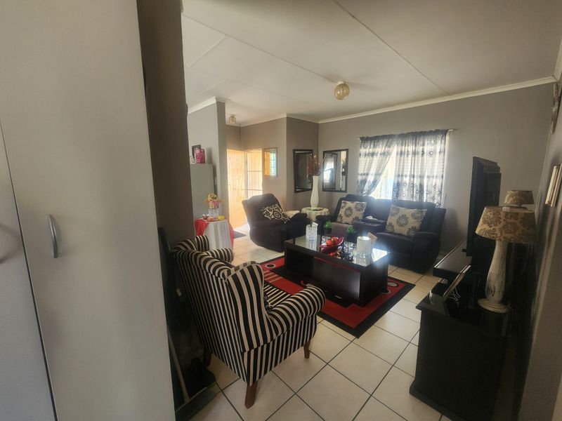 A comfortable living room featuring tiled flooring and coved ceilings, providing a functional and inviting space for relaxation.