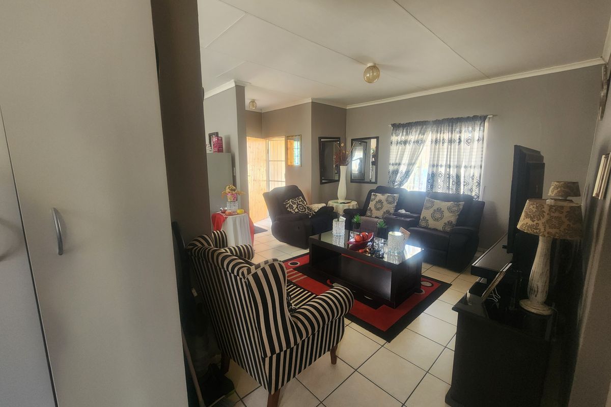 A comfortable living room featuring tiled flooring and coved ceilings, providing a functional and inviting space for relaxation.