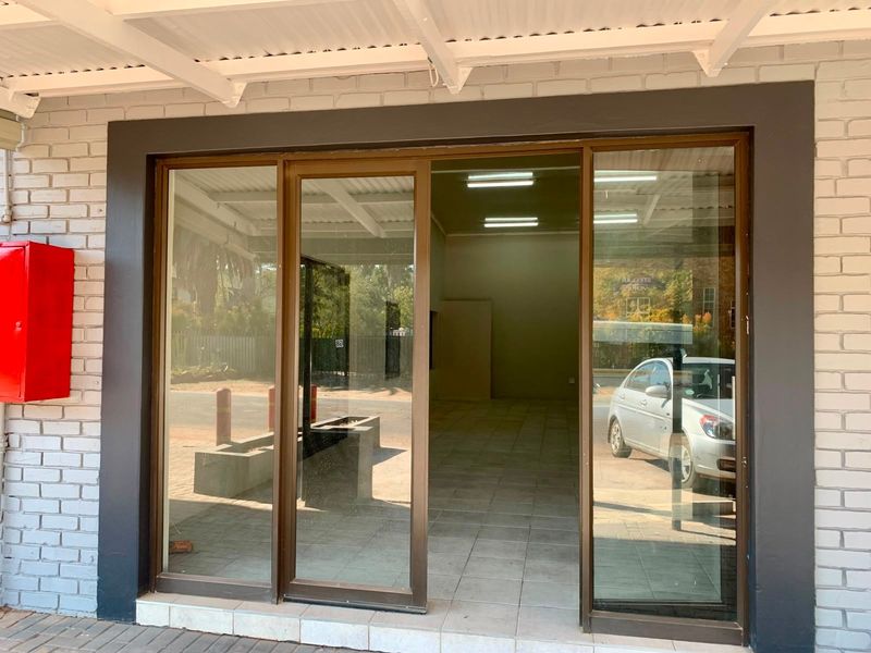 Entrance to an office space featuring a sliding glass door, tiled flooring, and a wall-mounted fire extinguisher cabinet.