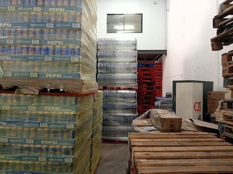 Industrial warehouse utility space featuring a mezzanine level, concrete flooring, and a high-level sliding window for ventilation.