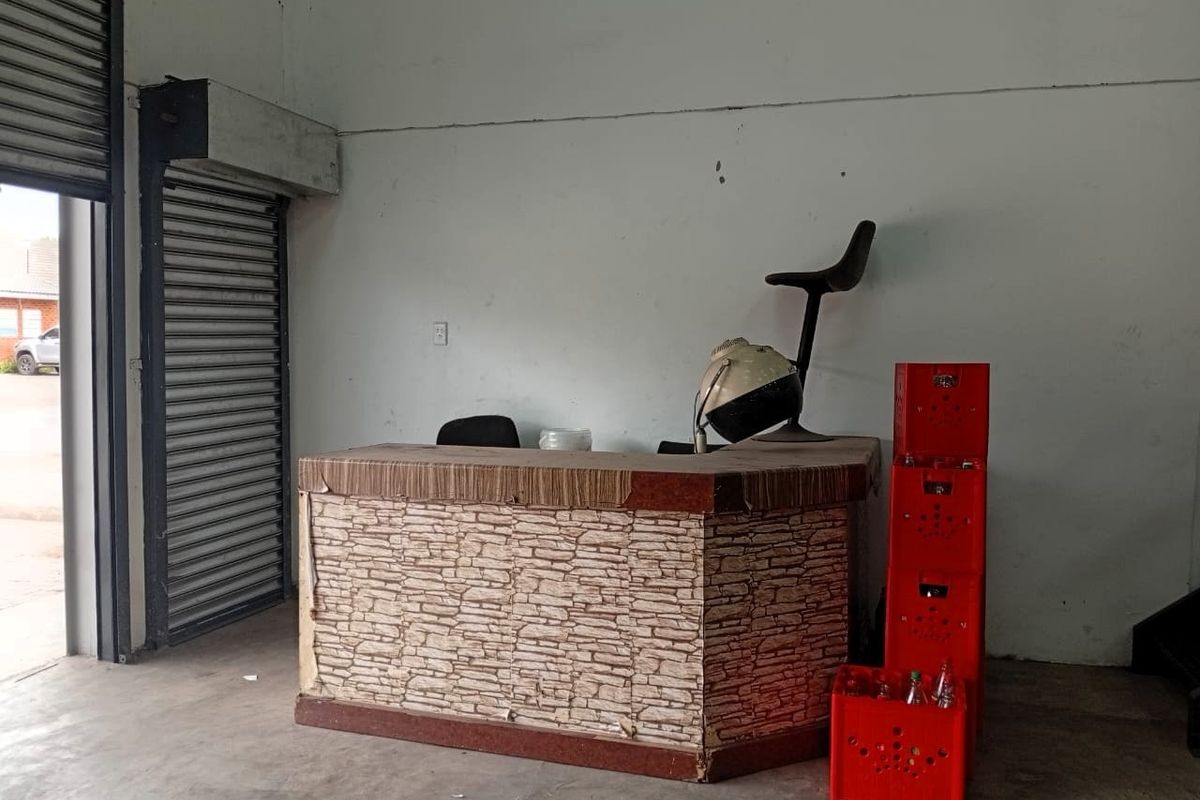 Industrial entry space featuring a concrete floor and a secure roller shutter door, suitable for a reception or service area.