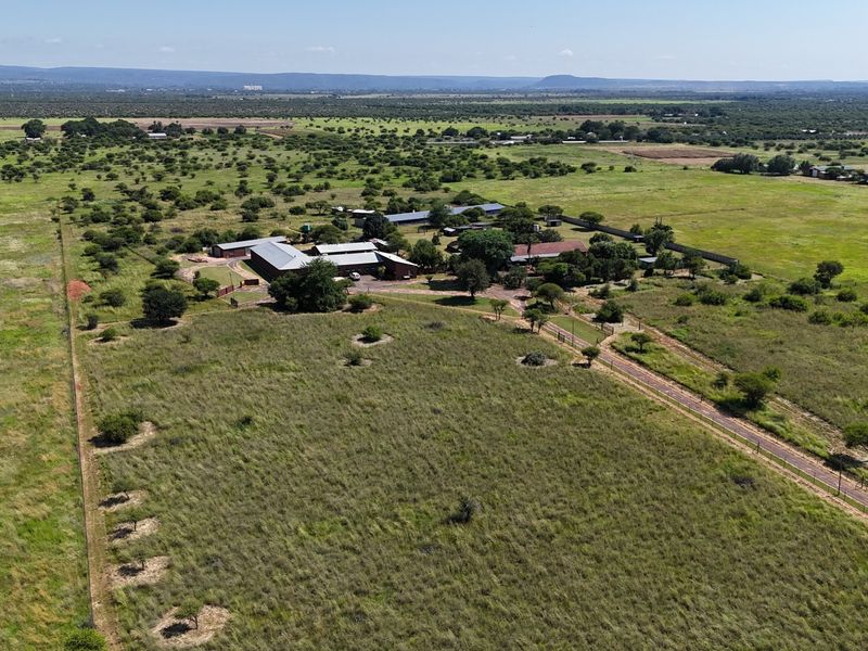 Aerial view of a large small holding property featuring multiple outbuildings, a main dwelling, and extensive surrounding grazing land.