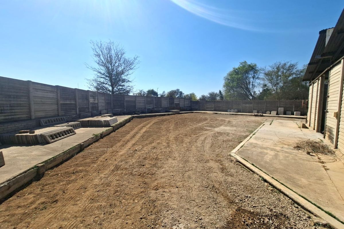 Spacious industrial yard area featuring a concrete apron, precast concrete boundary walls, and direct access to the main building structure.