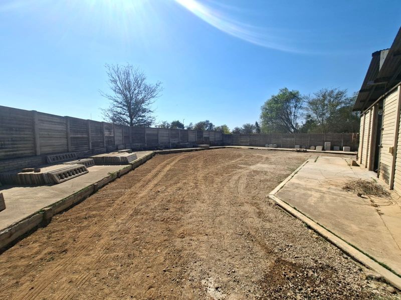 Spacious industrial yard area featuring a concrete apron, precast concrete boundary walls, and direct access to the main building structure.
