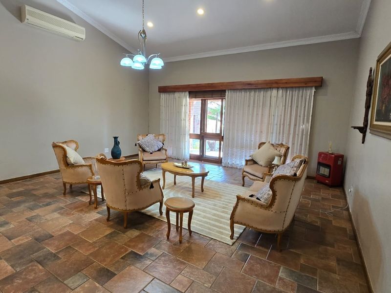 Spacious living room featuring tiled flooring, split-system air conditioning, and sliding glass doors leading to the exterior.