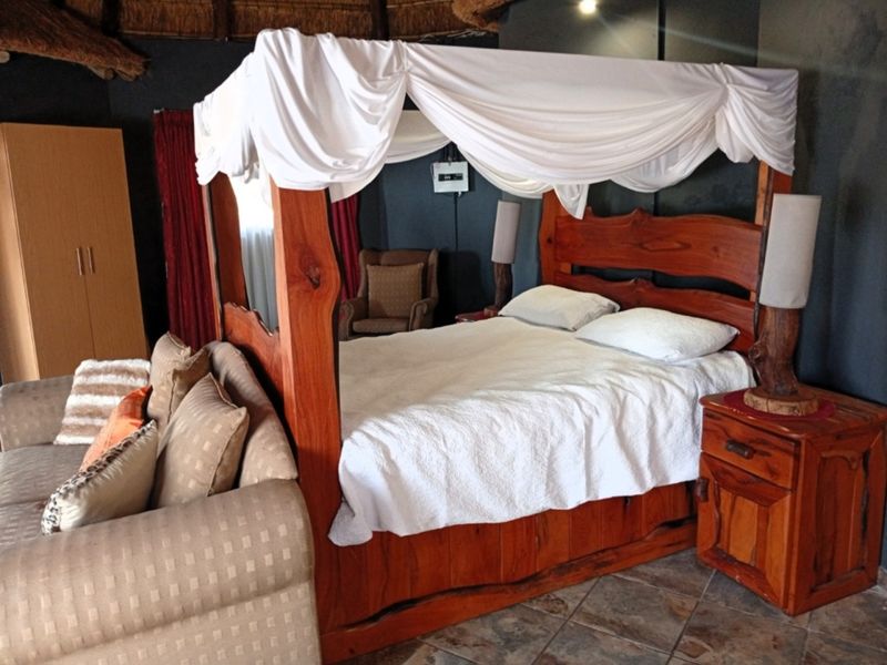 A bedroom featuring tiled flooring and a rustic thatched ceiling, creating a unique, textured interior space.