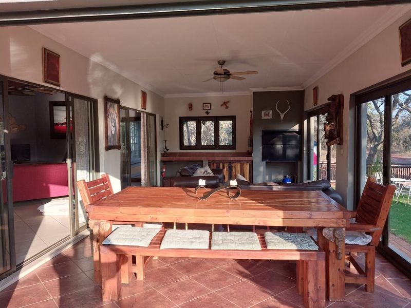 A spacious covered patio featuring tiled flooring, ceiling fan, and large sliding glass doors that provide seamless access to the outdoor area.
