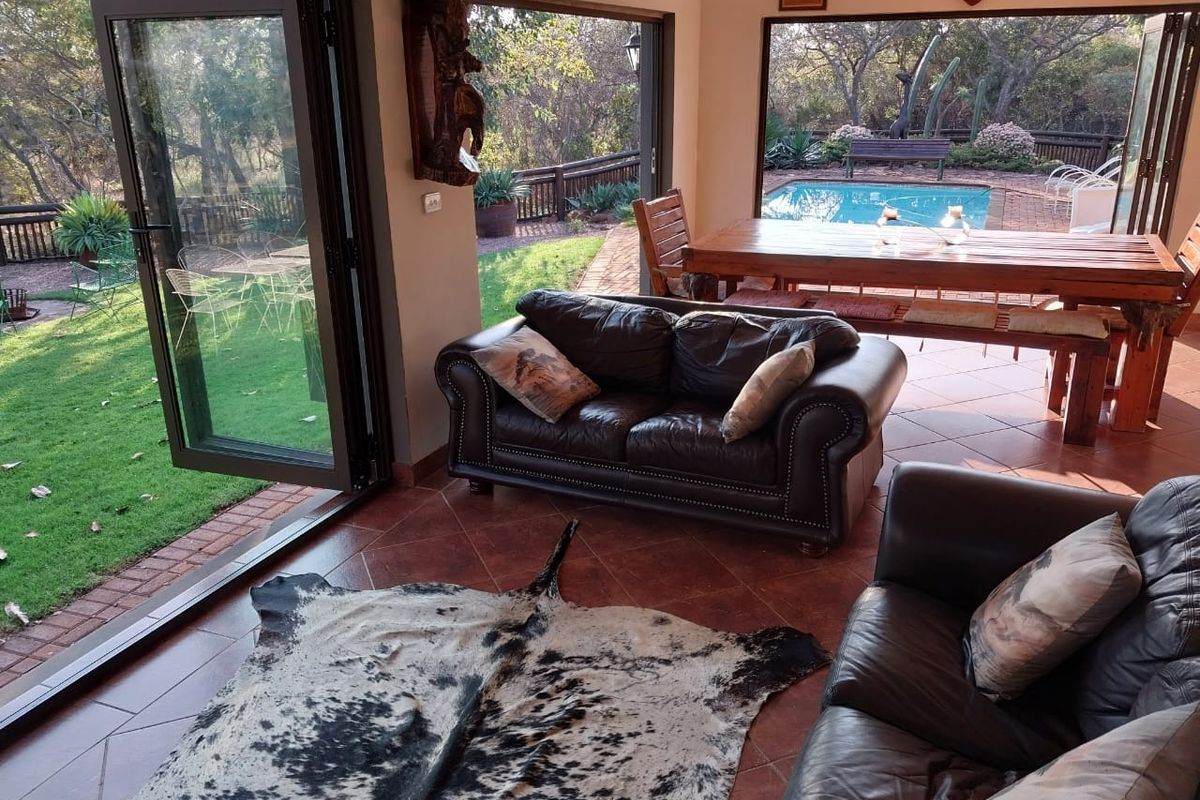 Spacious living area featuring terracotta floor tiles and large bi-fold doors that open directly onto the outdoor patio and pool area.