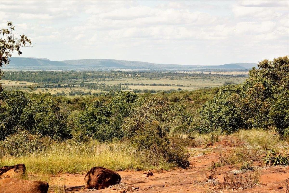 A scenic, elevated view overlooking expansive natural bushveld and rolling hills, showcasing the property's tranquil landscape and terrain.