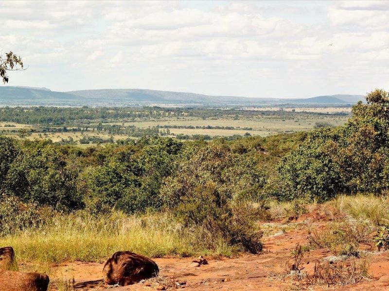 A scenic, elevated view overlooking expansive natural bushveld and rolling hills, showcasing the property's tranquil landscape and terrain.