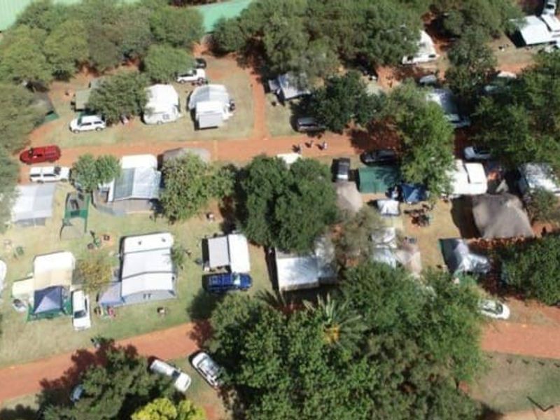 Aerial view of the lodge grounds featuring multiple camping and caravan sites nestled among mature trees and internal access paths.