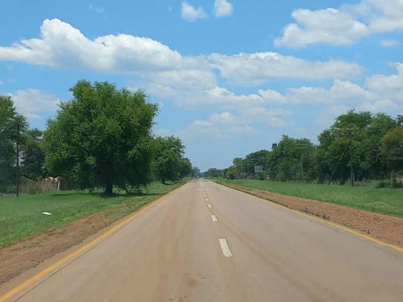 A view of the public road leading towards the property location, showing the surrounding rural landscape and approach.