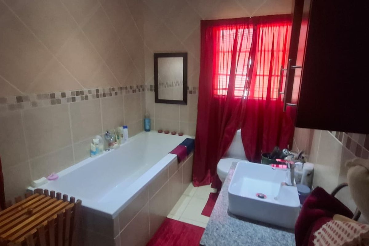 A functional bathroom featuring a built-in bathtub, a modern vessel sink on a stone vanity, and tiled wall finishes.