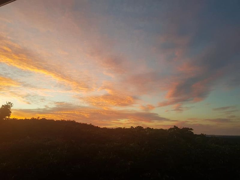 A scenic view of the sunset over the natural landscape surrounding the property.