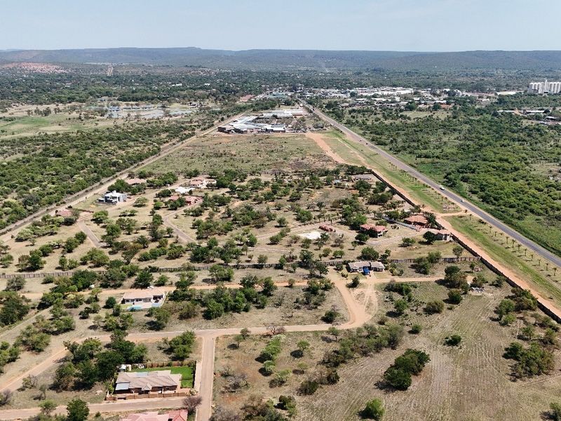 An aerial view of a residential estate featuring established vegetation, internal road infrastructure, and perimeter fencing within a semi-rural landscape.
