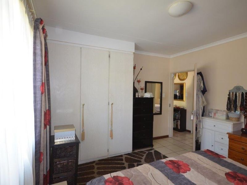 A functional bedroom featuring a built-in wardrobe and neutral wall finishes, providing a comfortable living space within the retirement village.