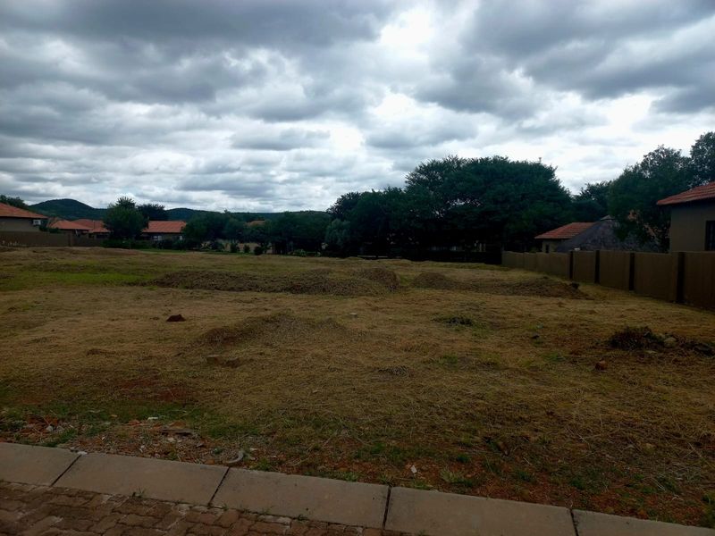 A vacant residential plot featuring a level-ready surface, boundary walling, and established neighbourhood surroundings, ideal for new construction.