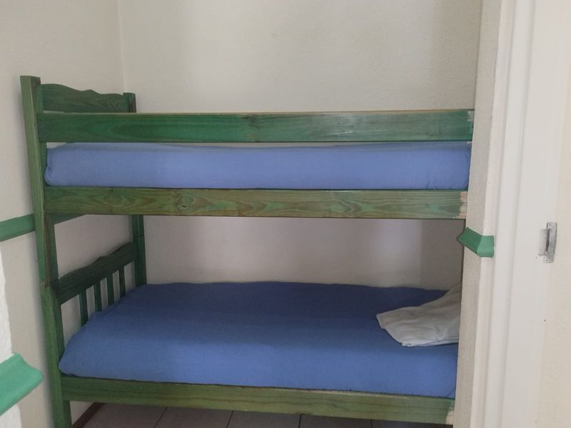 A compact bedroom space featuring tiled flooring and a built-in alcove area.