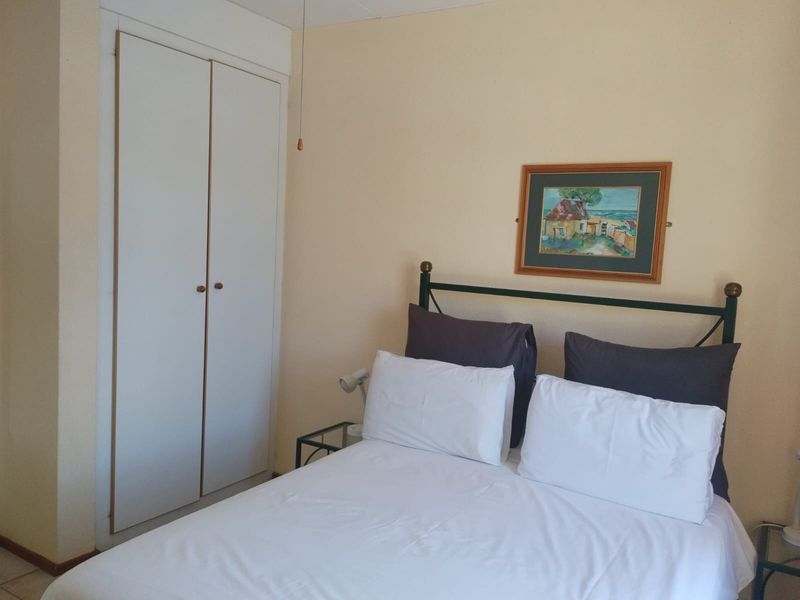 A functional bedroom featuring a built-in wardrobe and neutral wall finishes, offering a comfortable and practical living space.
