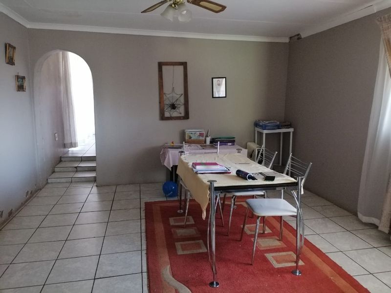 Dining room featuring tiled flooring, a ceiling fan, and an arched entryway leading to an adjacent space.