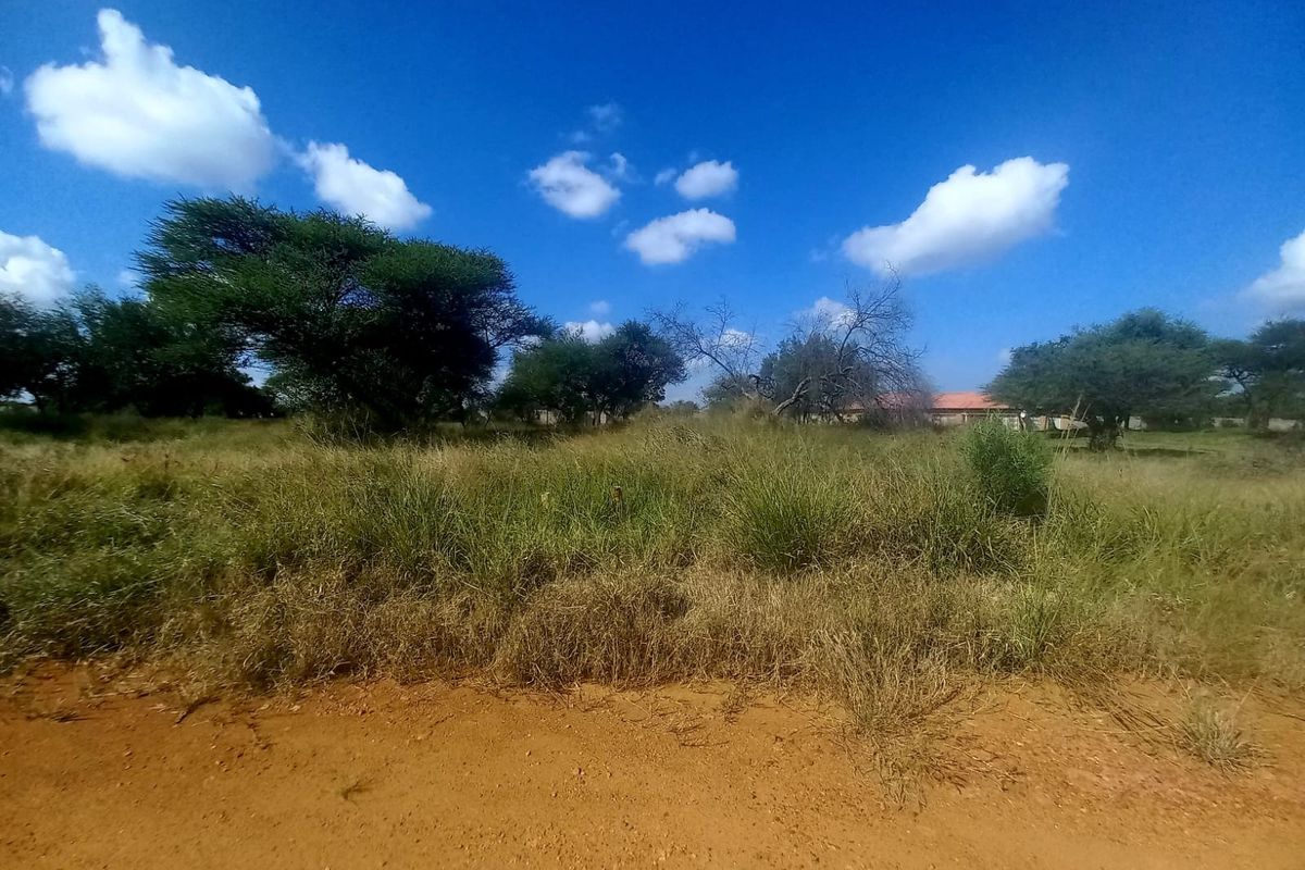 A view of a vacant residential plot featuring natural vegetation and unpaved access, suitable for future development.