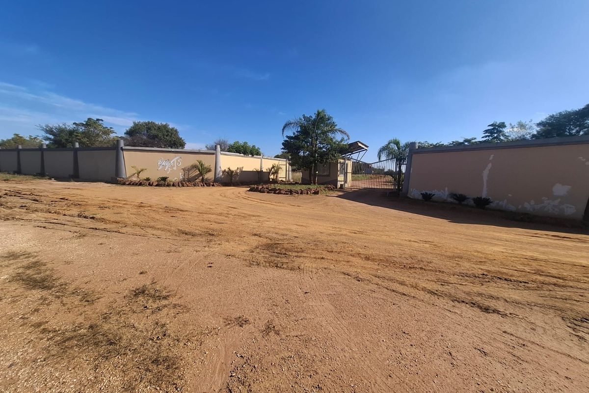 Front entrance view of the vacant residential property featuring a perimeter wall and gated access point.