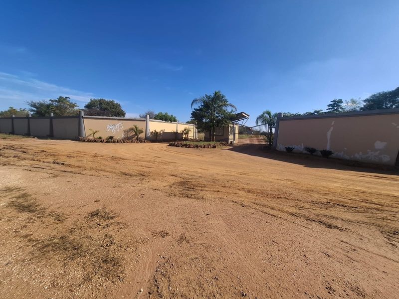 Front entrance view of the vacant residential property featuring a perimeter wall and gated access point.