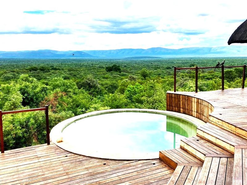 Elevated timber deck featuring a circular plunge pool with expansive panoramic views of the surrounding landscape.