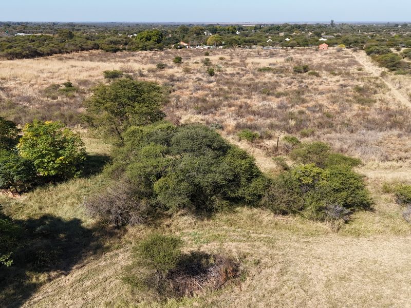 An aerial view of a large, undeveloped small holding plot featuring natural vegetation, indigenous trees, and open landscape.