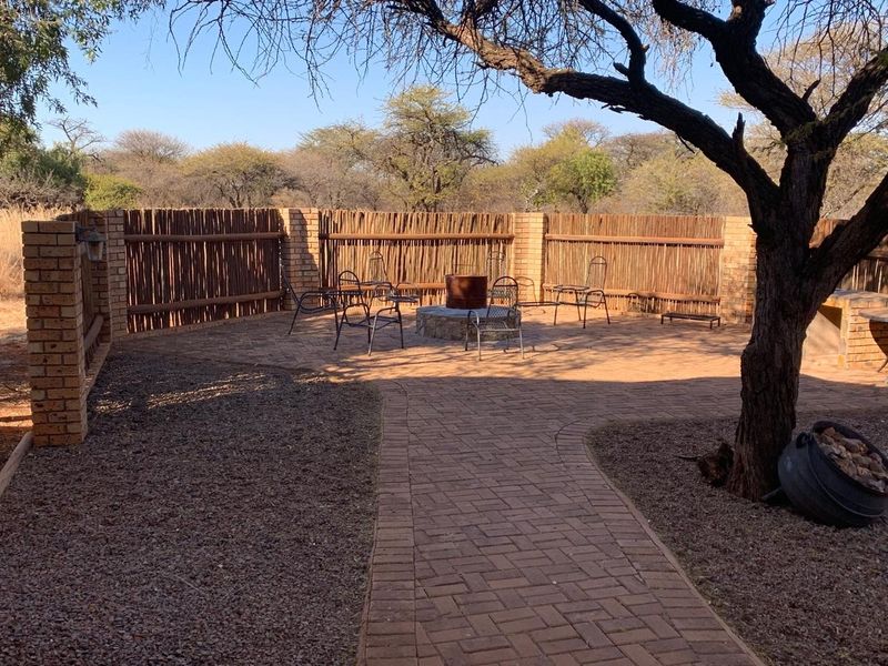 Outdoor entertainment area featuring brick paving, a built-in fire pit, and a brick boundary wall with integrated reed fencing.
