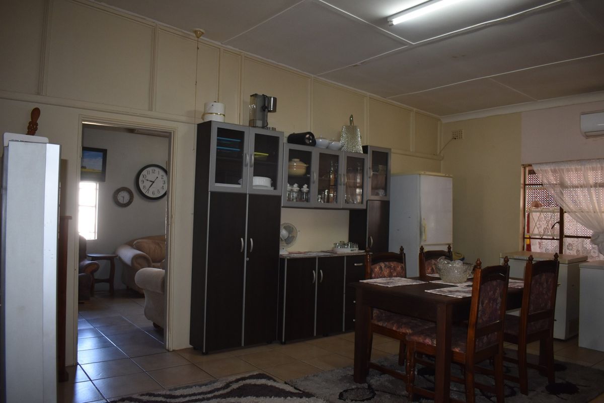 A functional kitchen area featuring built-in cabinetry and tiled flooring, offering potential for modernization and aesthetic updates to improve the overall living space.
