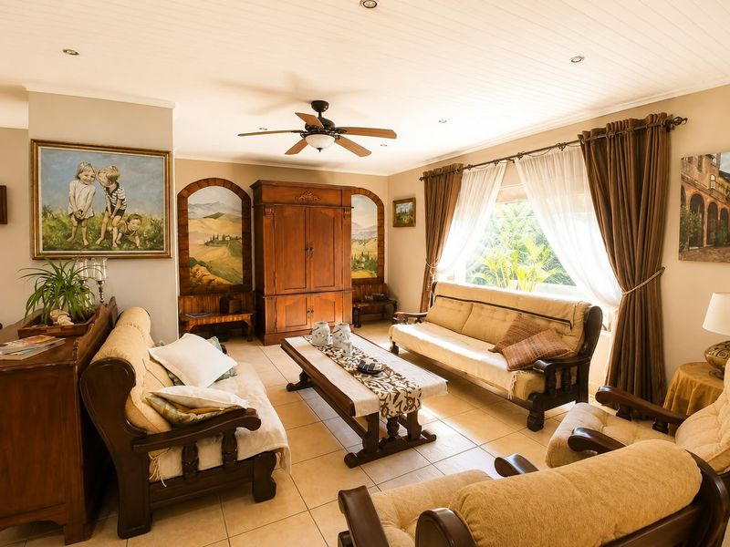 A comfortable living room featuring tiled flooring, a ceiling fan, and recessed lighting, offering a warm and inviting space for relaxation.