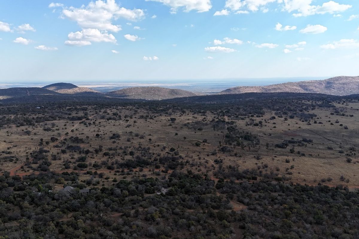 An expansive aerial view of the natural landscape, showcasing the vast terrain and surrounding hills.