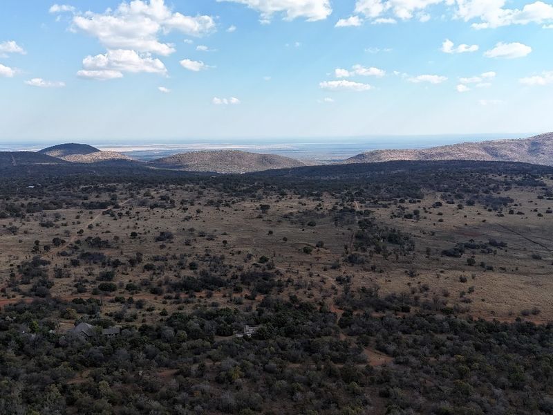 An expansive aerial view of the natural landscape, showcasing the vast terrain and surrounding hills.