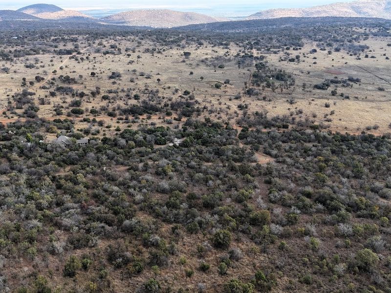 An aerial view of a large, undeveloped residential land parcel featuring native bushveld vegetation and expansive natural terrain.