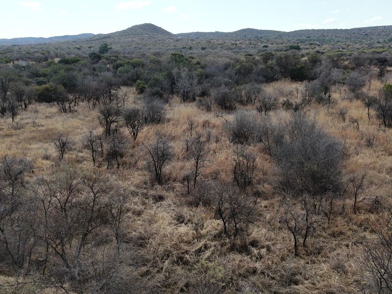 An aerial view of a vacant residential plot featuring natural bushveld vegetation and rolling landscape.