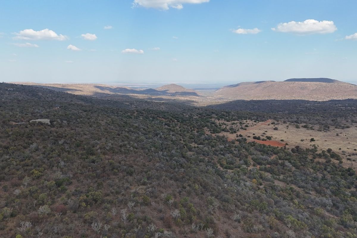 An aerial view of the expansive, undeveloped residential land featuring natural bushveld terrain and scenic mountain vistas.