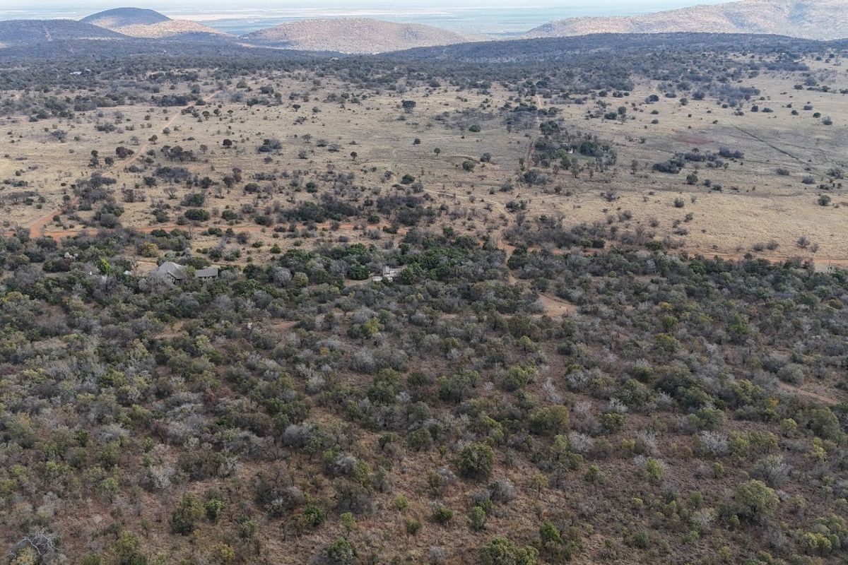 An aerial view of a large, undeveloped residential land parcel featuring natural bushveld vegetation and expansive landscape views.