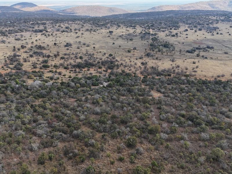 An aerial view of a large, undeveloped residential land parcel featuring natural bushveld vegetation and expansive landscape views.