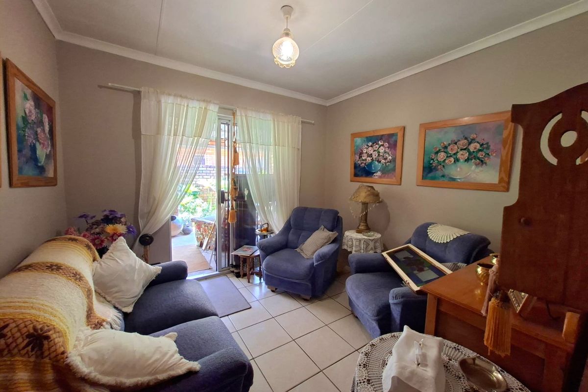 A cozy living room featuring tiled flooring and a sliding glass door providing access to the outdoor area.