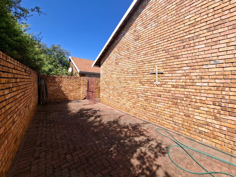 A private rear courtyard featuring paved flooring and high brick boundary walls, providing a secure and low-maintenance outdoor space.