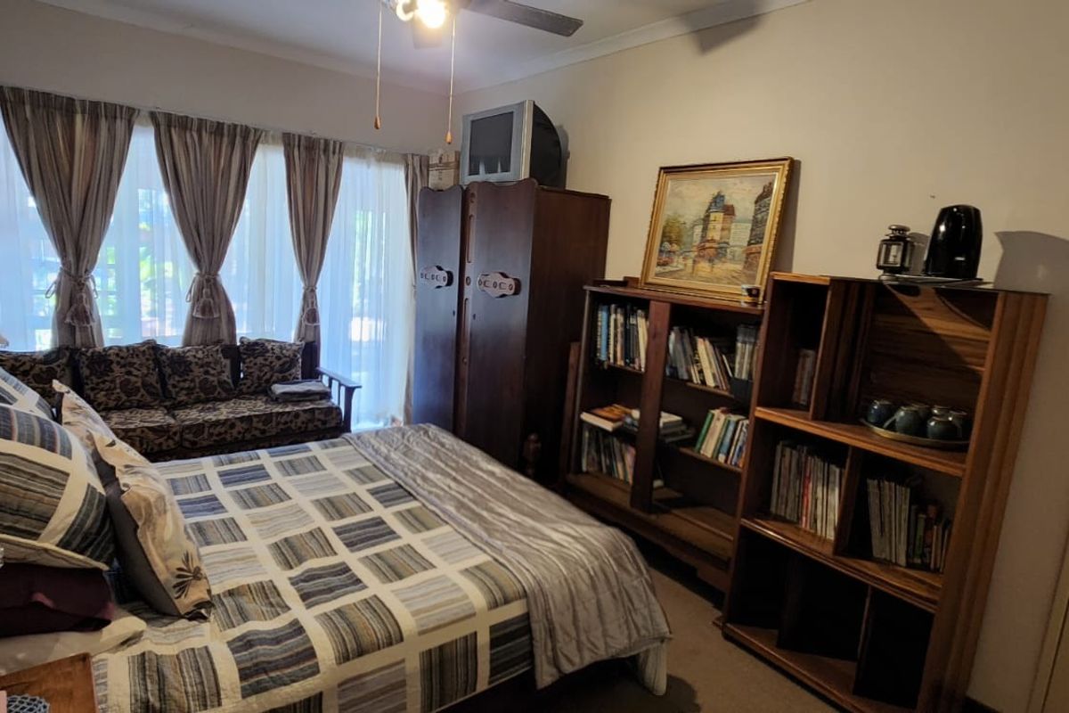 A bedroom featuring a ceiling fan and a sliding glass door providing access to the exterior.