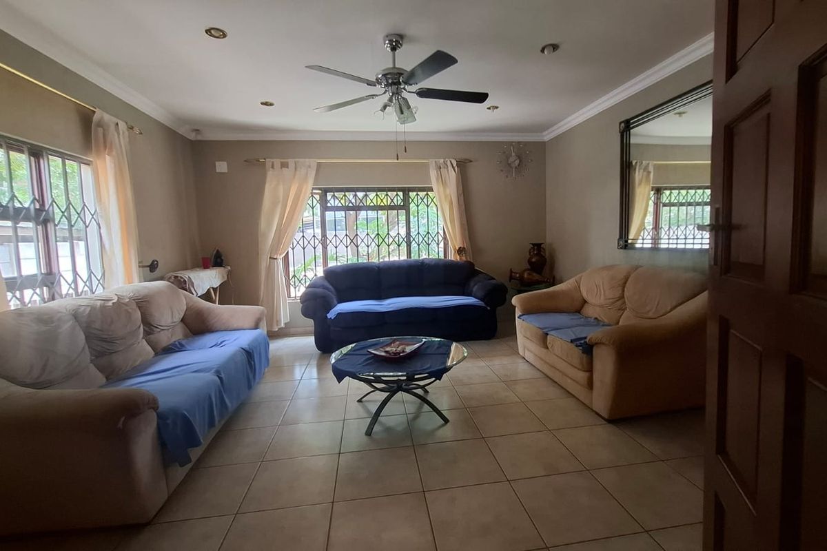 Spacious living room featuring tiled flooring, recessed lighting, a ceiling fan, and security bars on the windows.