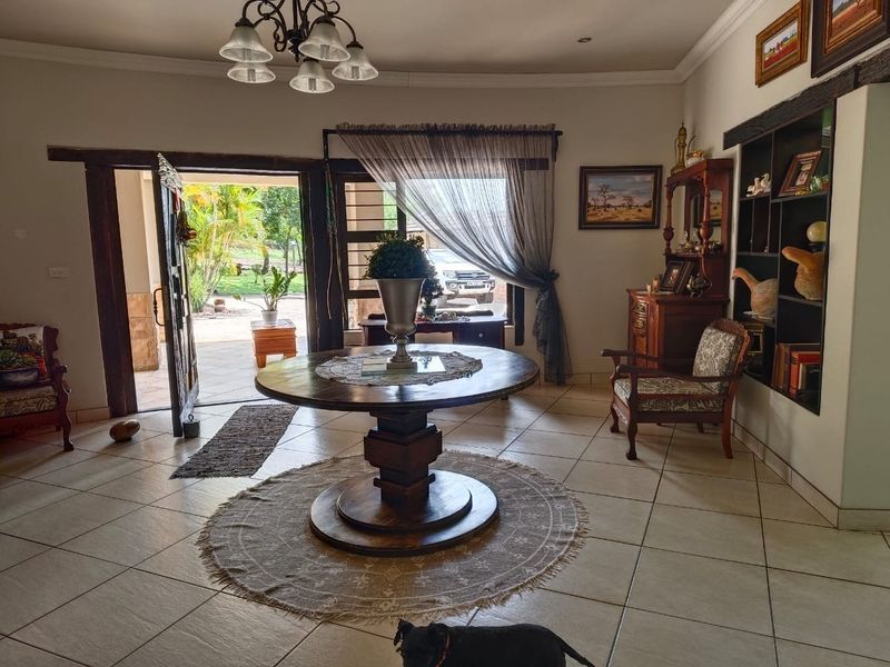 Spacious entrance hall featuring tiled flooring, a built-in display shelf, and direct access to the outdoor patio area.