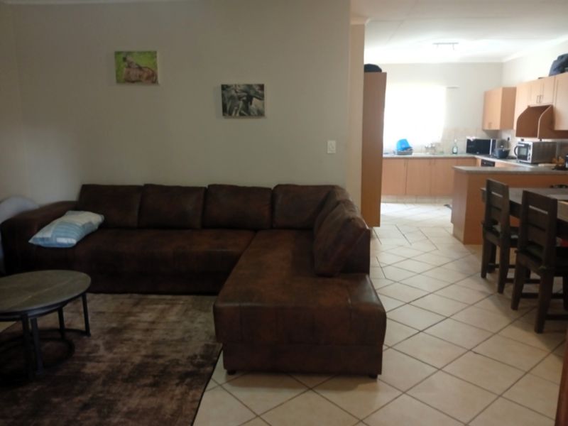 Open plan living and kitchen area featuring tiled flooring and functional kitchen cabinetry with a breakfast nook.