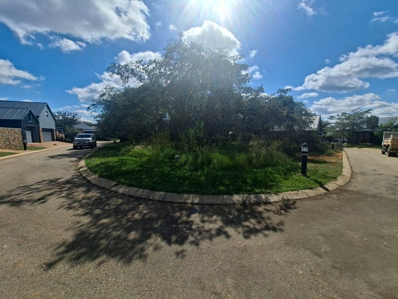 A view of a residential street cul-de-sac featuring paved roads, concrete curbing, and established landscaping within a residential estate.