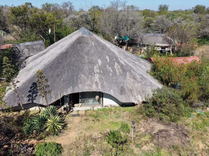 Aerial view of a small holding property featuring a traditional thatched roof dwelling surrounded by natural bushveld vegetation.