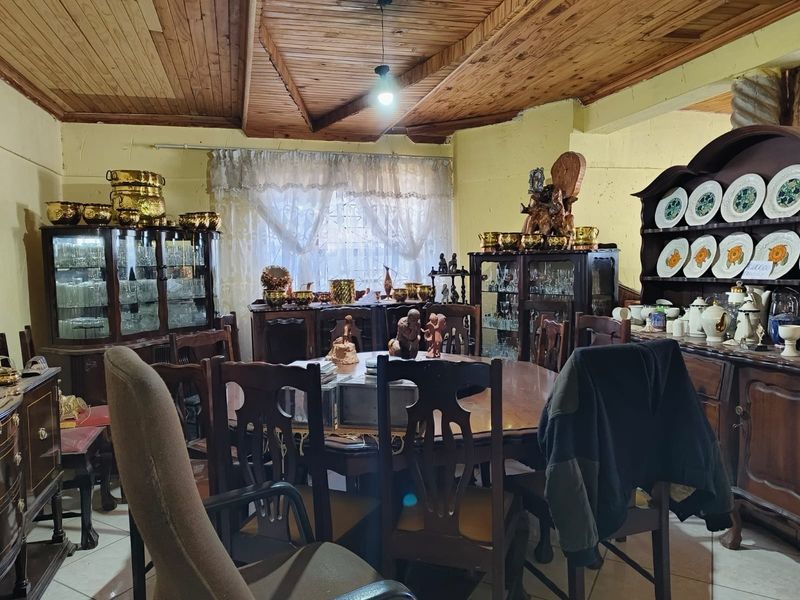 A traditional dining room featuring a timber-clad ceiling and tiled flooring, offering a classic layout ready for modern updates.