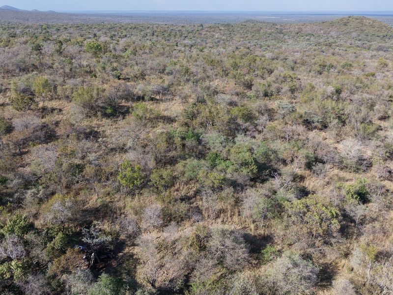 An expansive aerial view of the natural bushveld landscape, showcasing the vast, undeveloped terrain of the farm property.